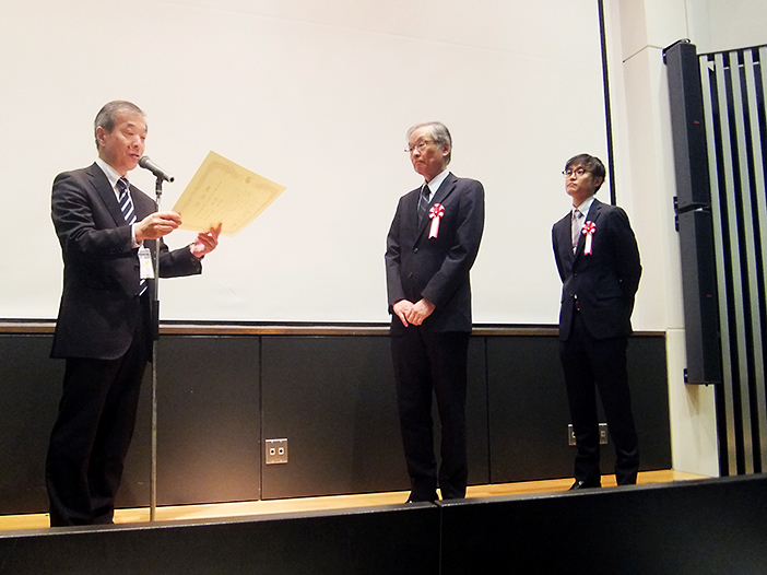 授賞式にて表彰を受ける岡本教授（中央）と鮱名さん（右）（日本航空宇宙学会より提供）