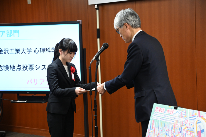 国土交通省で行われた表彰式で賞状を受け取るメンバーの成島束咲さん