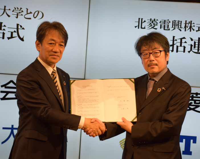調印後、握手する北菱電興株式会社 小倉 一郎代表取締役社長（写真右）と金沢工業大学　大澤 敏学長(写真左)