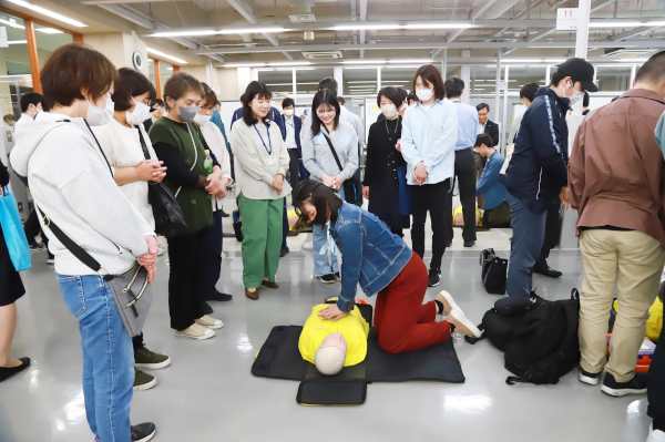 訓練用人体模型で心臓マッサージを体験する学生