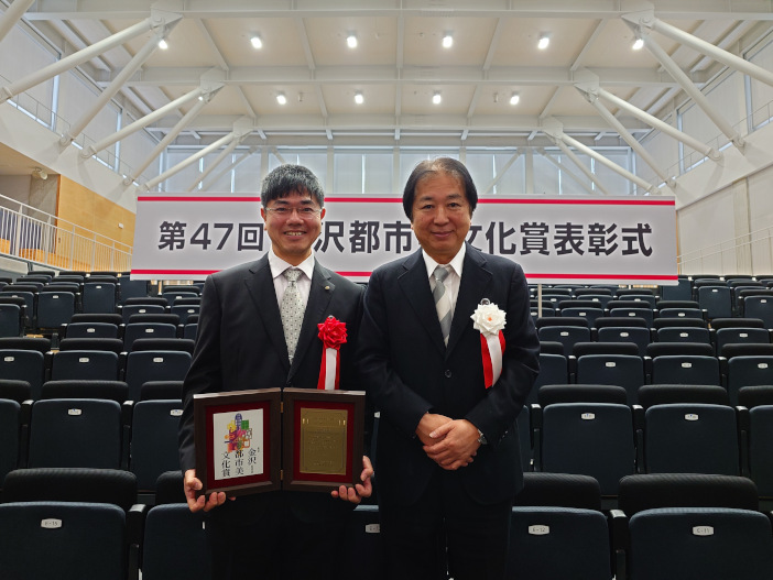 表彰式終了後、蜂谷部会長（写真右）と。<br>蜂谷部会長は受賞作品10件のうち、「友禅流しのベンチ」は建物以外の唯一の受賞作品だったと評価した
