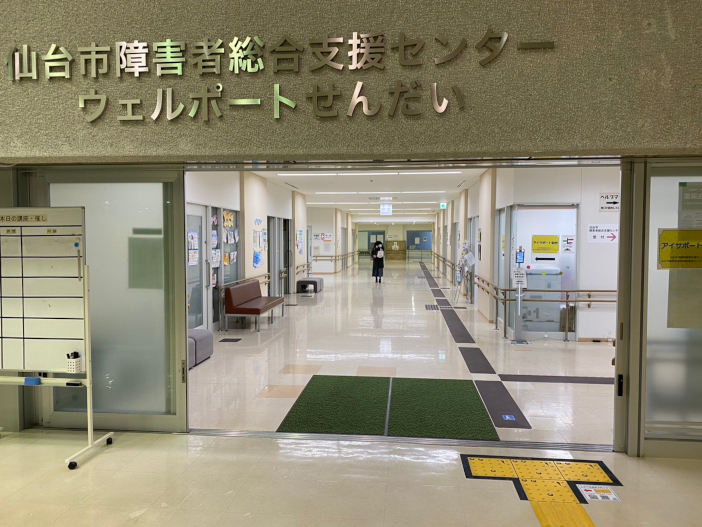 ウェルポートせんだい前に敷設された『コード化点字ブロック』（写真右手前）。<br class="hidden-sp">スマホ専用のアプリで読み取ることにより、現在位置や周辺の施設、設備を音声案内する