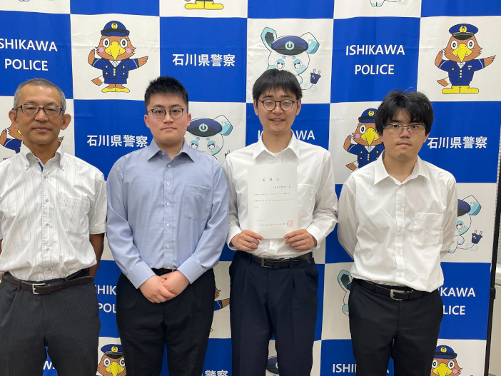 委嘱状を手渡された情報セキュリティ・スキルアッププロジェクトメンバー。写真右から伊熊 涼介さん（情報工学科3年）、志田 愛斗さん（情報工学科3年）、橘 真吾さん（情報工学科3年）と指導教員の情報工学科 向井 宏明教授