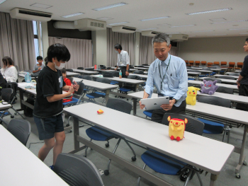 「写真を使って3Dモデルをつくる」プログラム：<br>中野教授が見本になり、子どもたちと一緒に撮影する様子