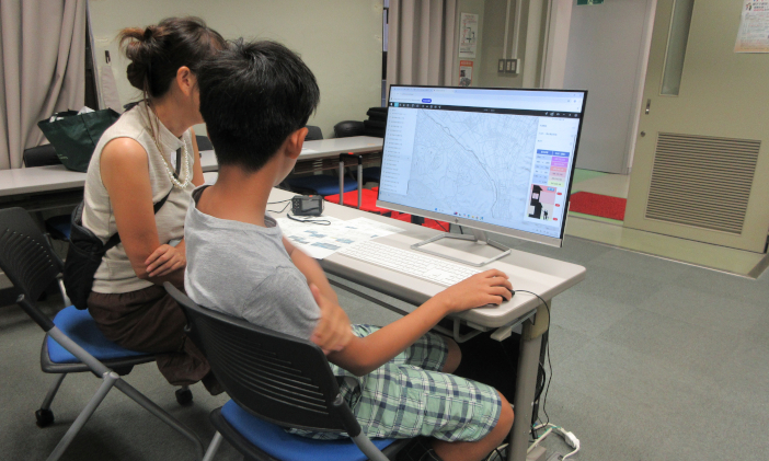国土交通省が公開している都市3Dデータを見る親子の様子