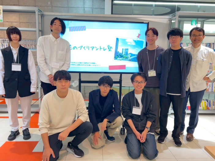 【ものづくりアントレ塾を開催した金沢工業大学起業部の皆さん】<br>写真左から、杉森 彩乃さん（電気電子工学科3年）、杉山 遥さん（建築学科3年）、前 賢志さん（メディア情報学科2年）、千野 恵汰さん（経営情報学科4年）、丹羽 樹さん（経営情報学科3年）、安部 芳大さん（建築学科4年）、高見 洋杜 さん（経営情報学科3年）、石原 正彦　経営情報学科教授