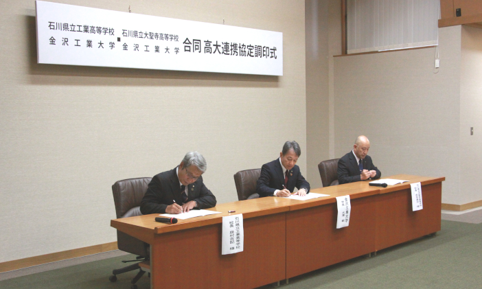 協定書に署名をする居村校長(左)・大澤学長(中)・𠮷本校長(右) 協定書に署名をする居村校長(左)・大澤学長(中)・𠮷本校長(右)