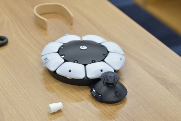 市販されているユニバーサルコントローラ（右手前の円盤状の装置）