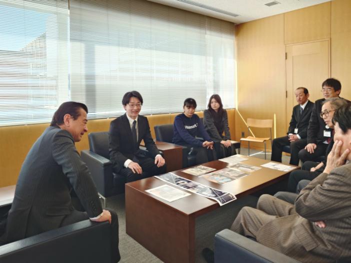 感謝状贈呈式に先立って行われた懇談。<br>写真左から粟貴章市長（写真左）、勝原講師、模型制作を主導した学生の沖田帆海さん、是川朋音さん。<br>大久保教育長をはじめ市の関係者や旧小学校校舎の最後の卒業生も出席して行われた