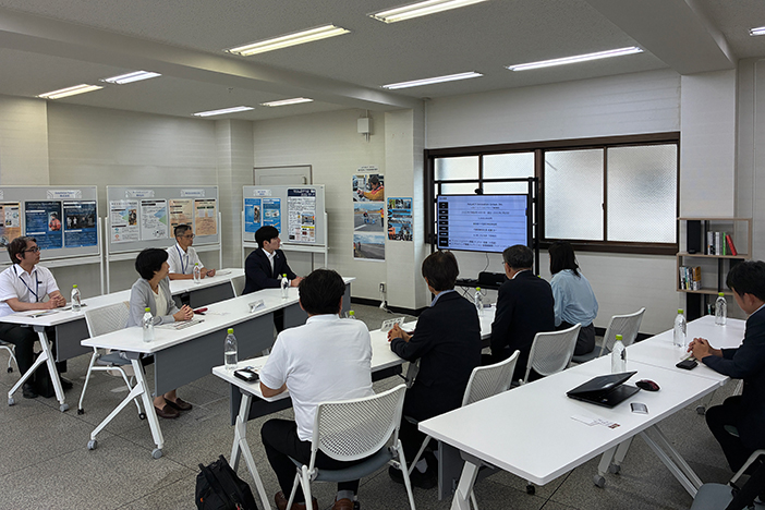 石田知事および県関係者（左側）へ、坂井市（右側）の新産業共創事業を説明<br>赤坂教授は、右側前列奥から3番目