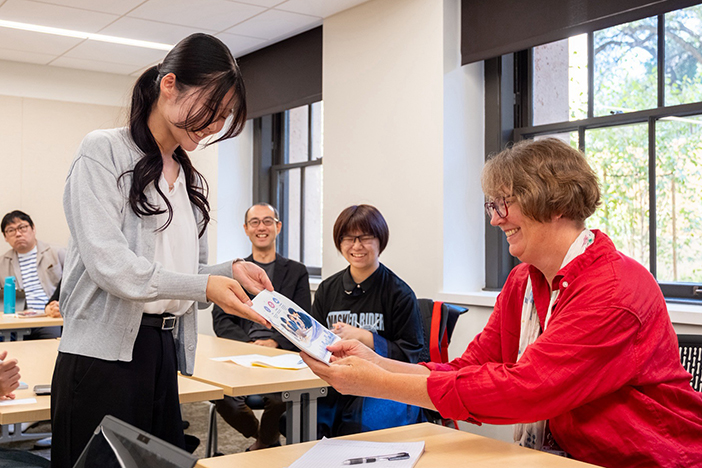 制作したパンフレットをForssell博士に手渡す金沢工業大学の学生 (スタンフォード大学で) 制作したパンフレットをForssell博士に手渡す金沢工業大学の学生<br>(スタンフォード大学で)