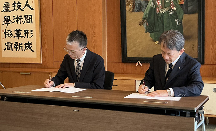 協定書に署名する森也寸司校長(左)と大澤敏学長(右)