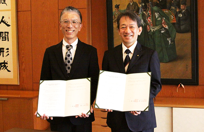 協定書を持つ森也寸司校長(左)と大澤敏学長(右)